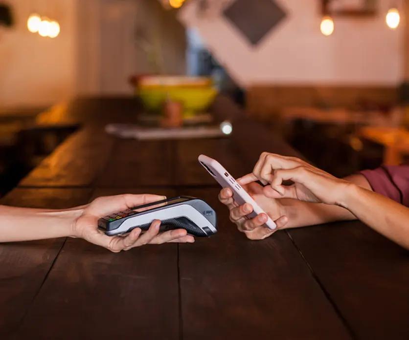 Using a smartphone digital wallet to make contactless payment at POS terminal in Lebanon — mobile payment convenience in action.